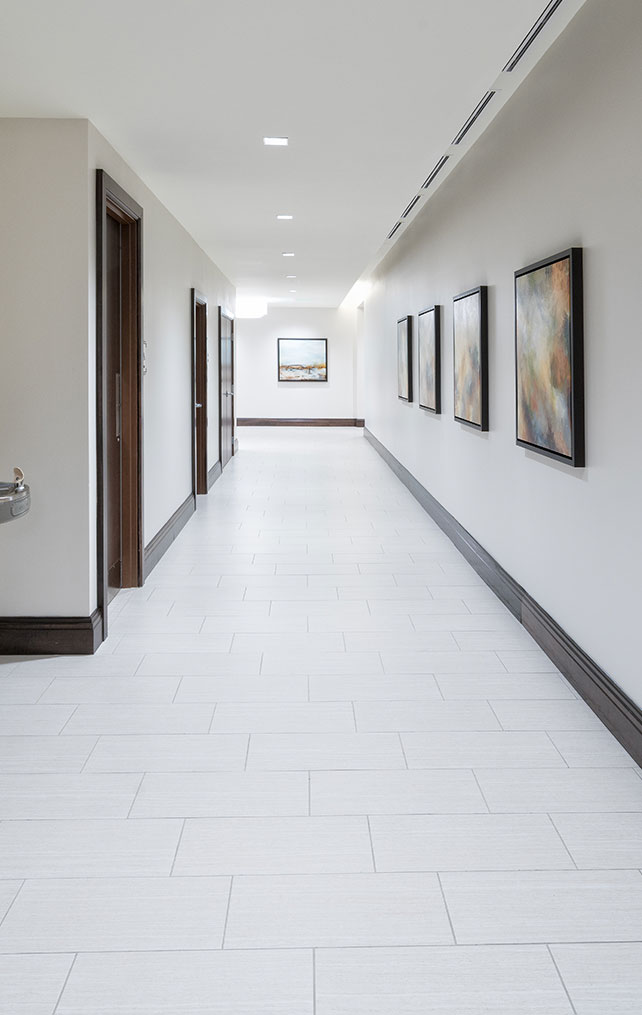 Commercial hallway with abstract art and dark wood details designed by Morton & Wasmer Builders