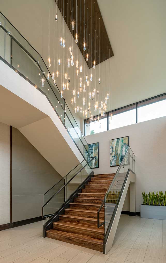 Commercial staircase with abstract light fixture and wooden steps designed by Morton & Wasmer Builders