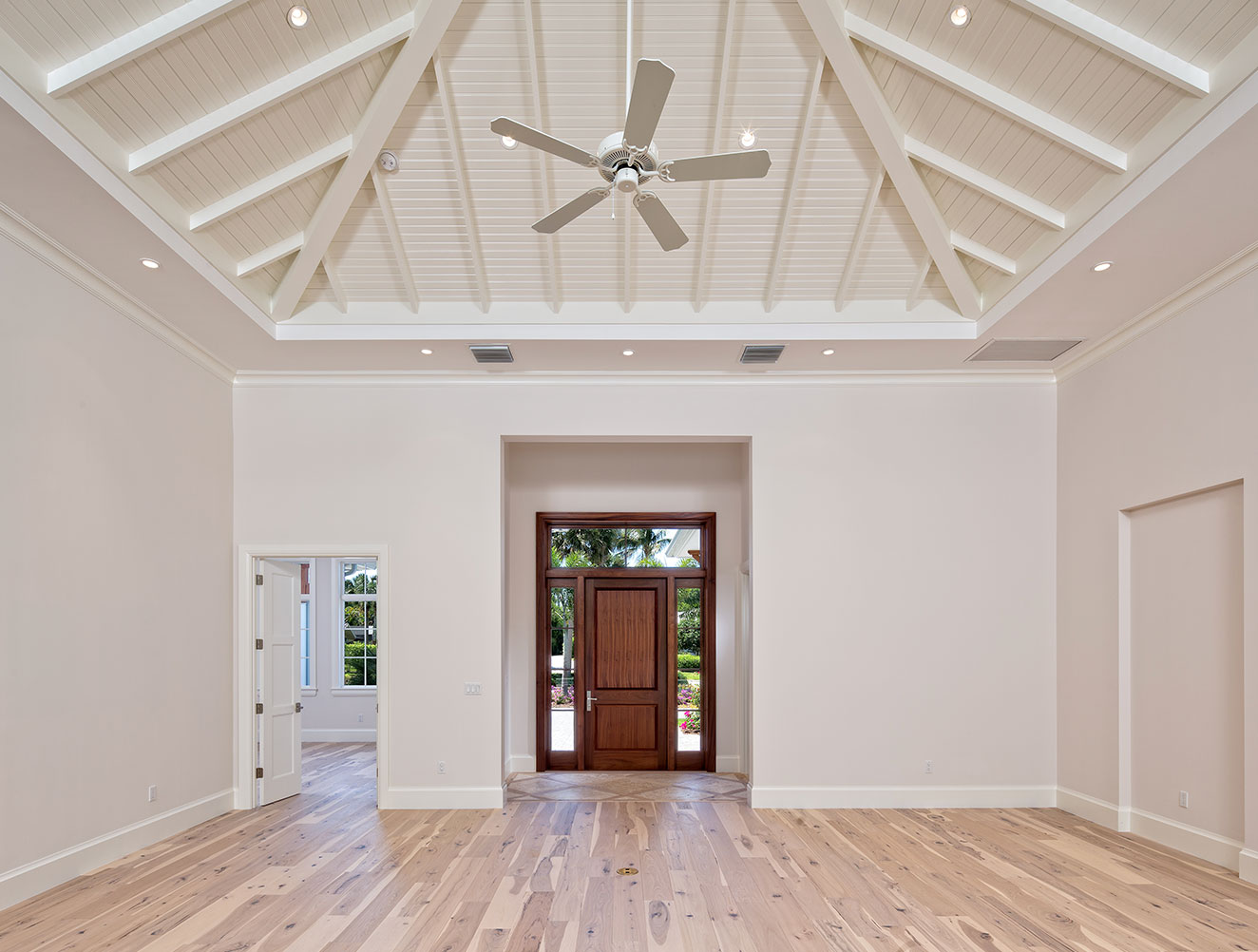 Front foyer and great room with decorative beam ceilings and hardwood flooring