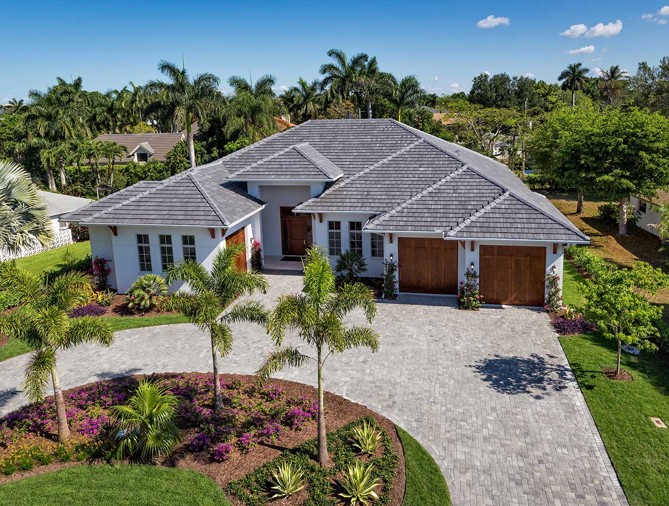 Aerial view of traditional Florida style Naples custom home with paver driveway