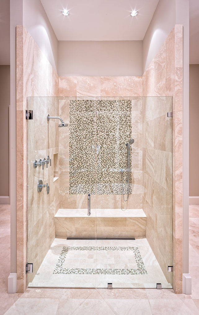 Master bathroom with shower bench and decorative tile in Naples custom home Mooring Line